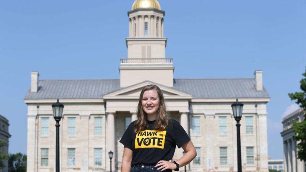 Image of Jocelyn Roof standing in front of the Old Capitol wearing a Hawk the Vote shirt.